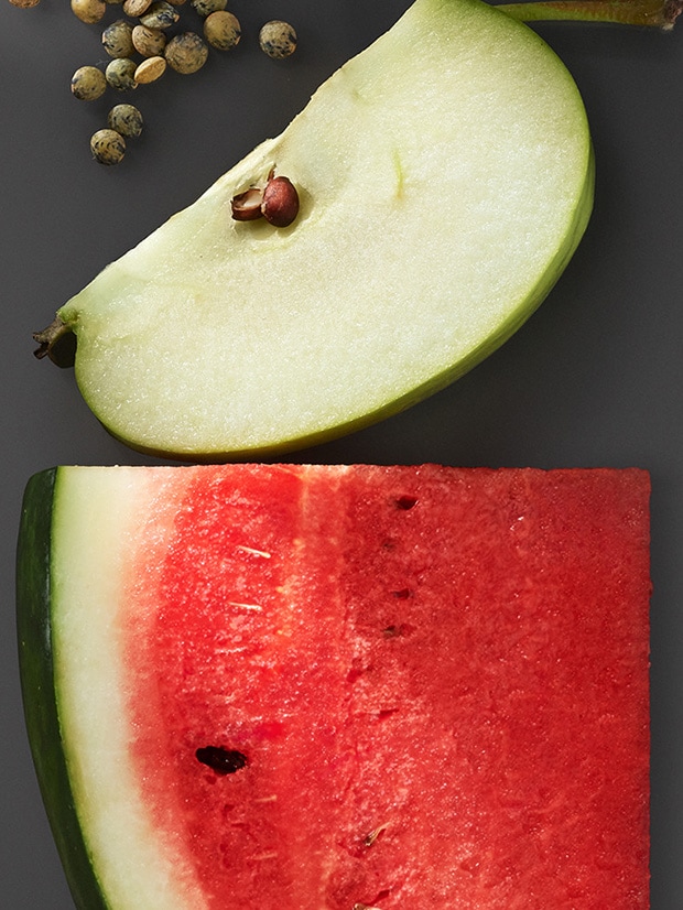 Close up of apple and watermelon slice on a dark grey background